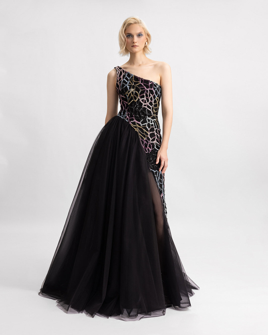 A one-shoulder beaded black evening dress with an asymmetrical tulle skirt.