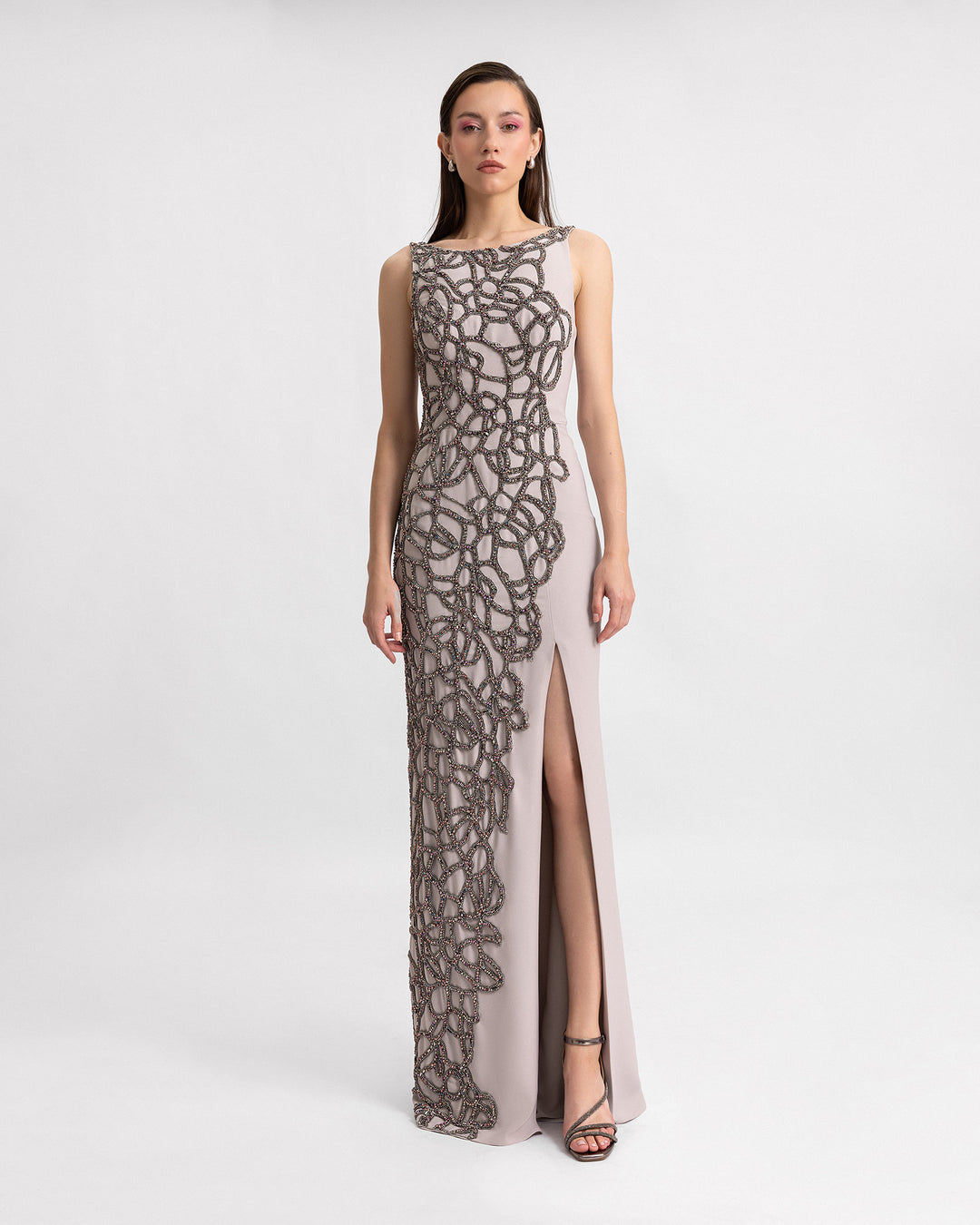 A slim-cut evening dress with asymmetrical beading details and a slit on the side.