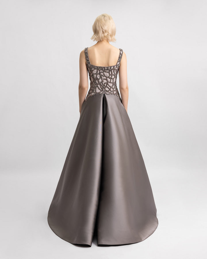 The back of a beaded evening dress featuring a mikado draped tail.