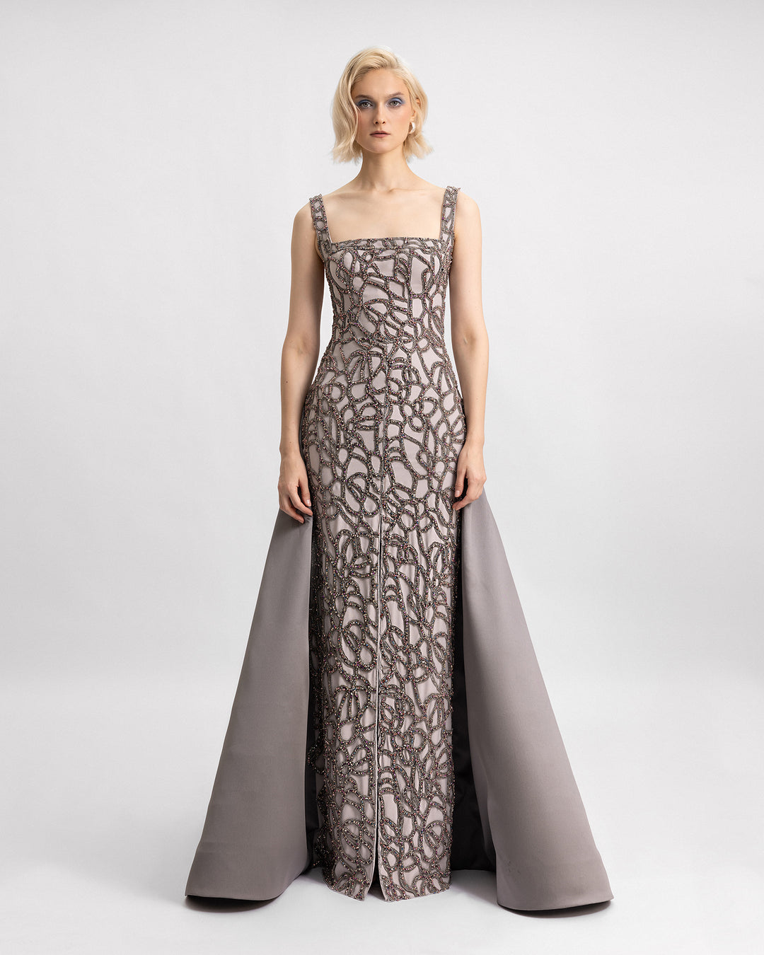 A square neckline beaded dress featuring a slit in the middle and a mikado draped tail.