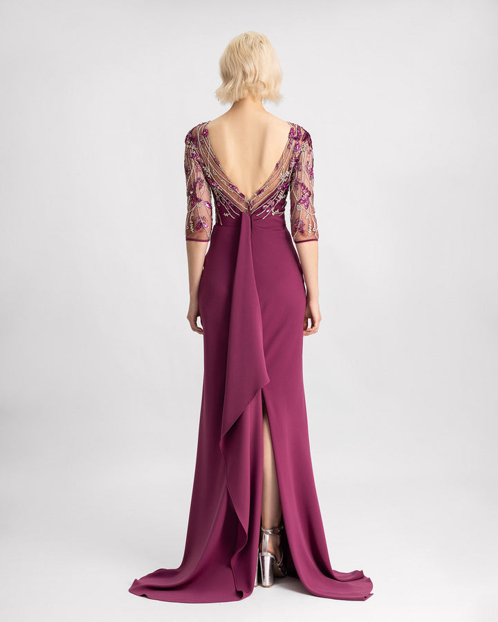 The back of a slim-cut evening dress in mulberry color with a beaded corset, three-quarter sleeves, and a slit at the back.