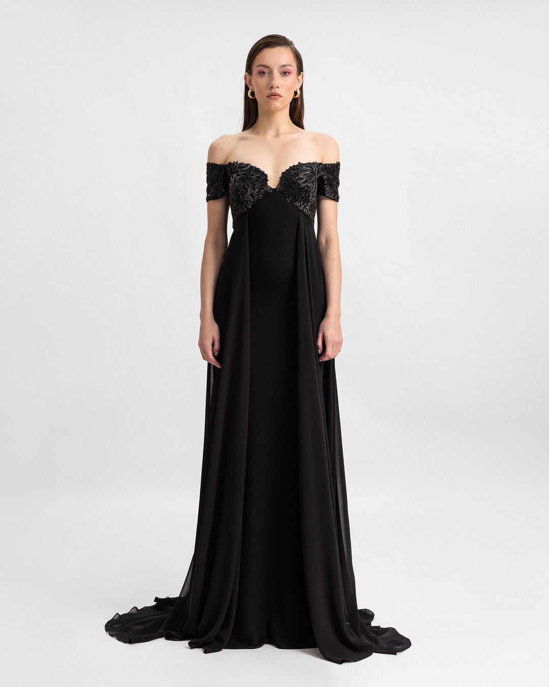 A beaded off-the-shoulders black evening dress with long gathered chiffon strips on the sides.