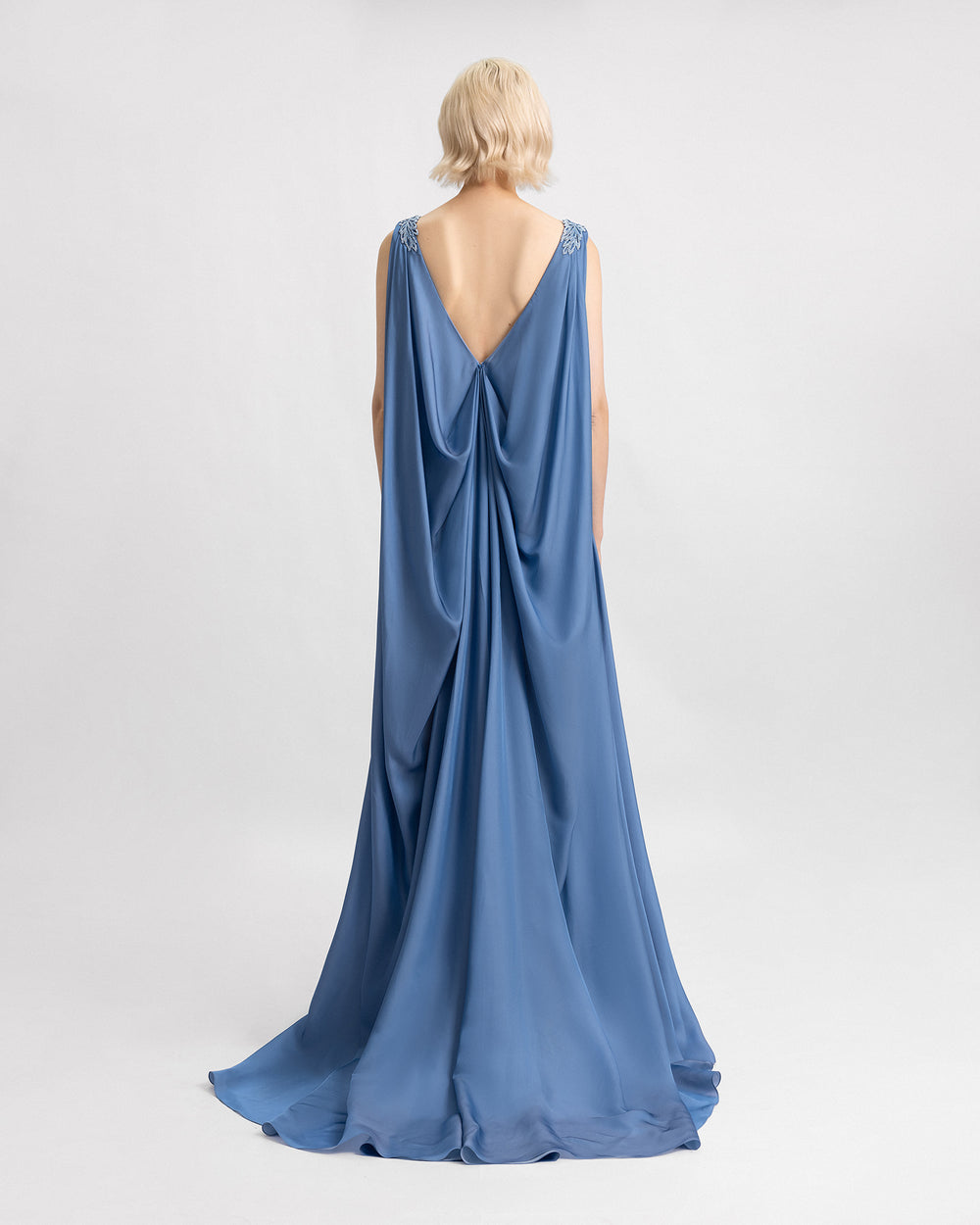 A blue evening dress with a draped flowy silk chiffon back.