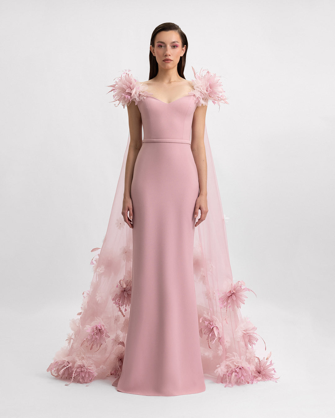 A slim-cut pink evening dress with a long organza 3D floral cape.