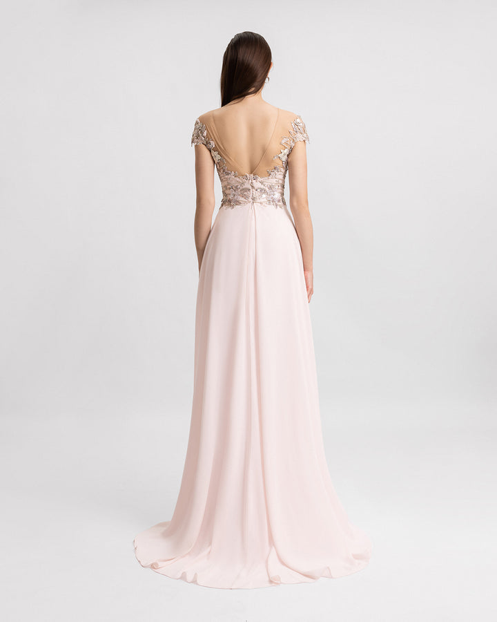 The back of a long pink evening dress with a cut-out beaded corset and a crepe georgette skirt.