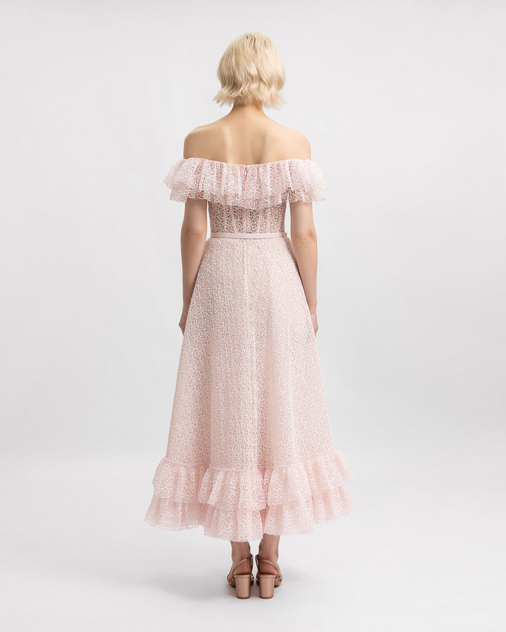 The back of An off-the-shoulders pink midi dress featuring ruffles on the neckline and hemline and a detachable belt. 