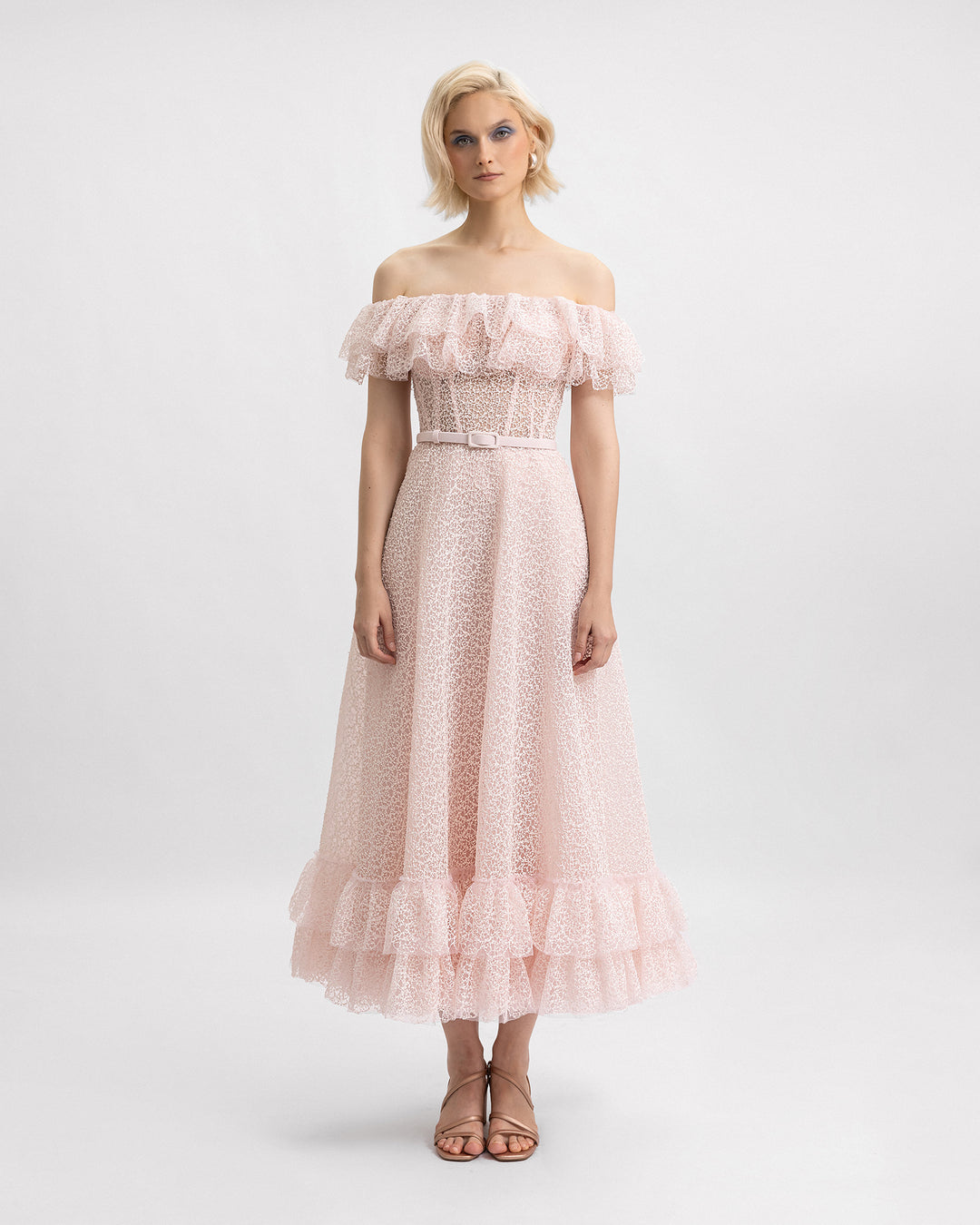 An off-the-shoulders pink midi dress featuring ruffles on the neckline and hemline and a detachable belt. 