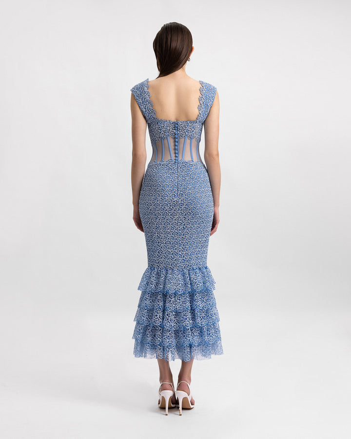 The back of a v-neckline midi dress featuring a see-through corset and a ruffled hemline.