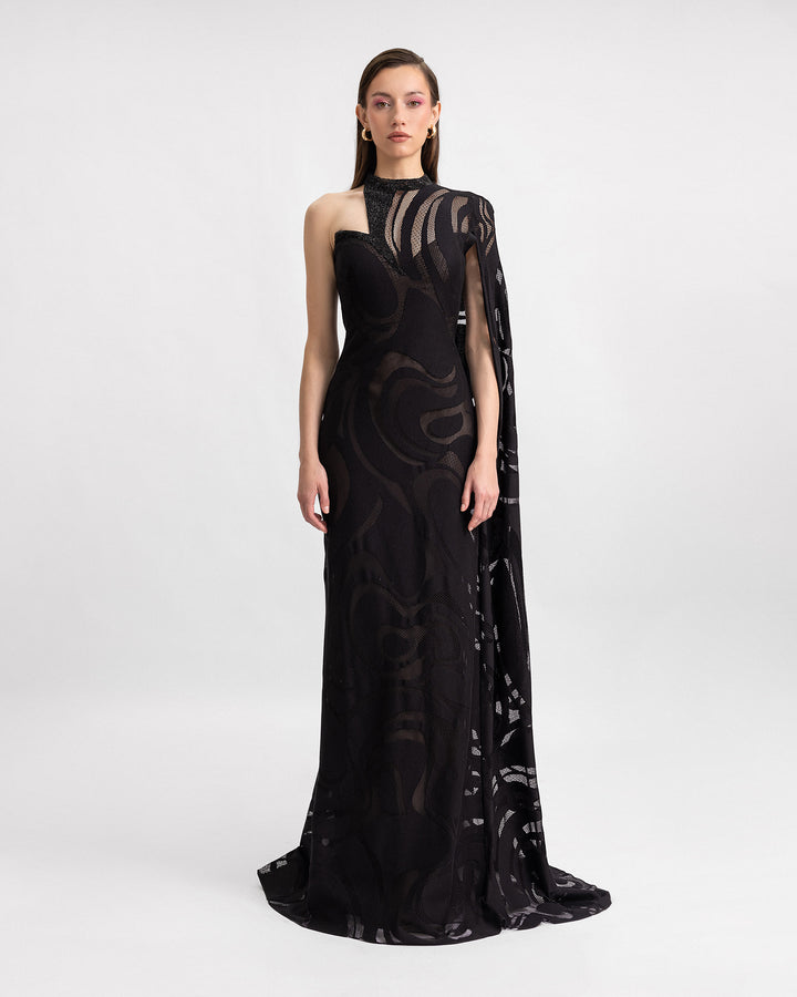 An asymmetrical neckline black evening dress with a floor-length sleeve and beading details on the corset.