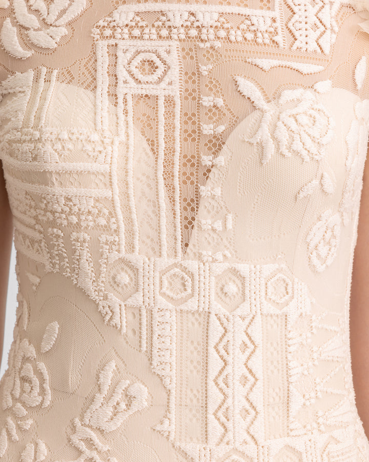 A close-up of a lace beige evening dress.