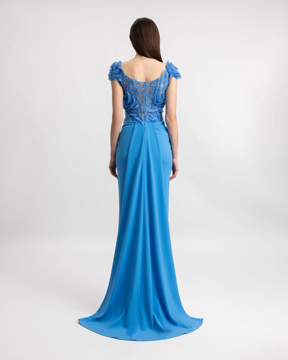 The back of a slim-cut blue evening dress featuring a floral embroidered corset and a draped skirt.