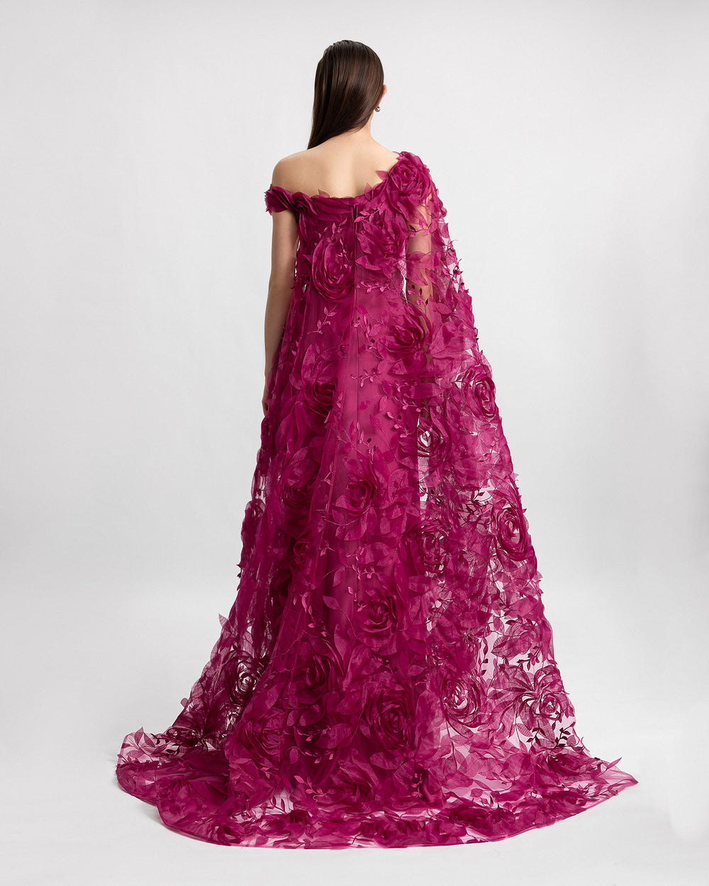 The back of an asymmetrical neckline evening dress in mulberry color with an embroidered floral organza cape.