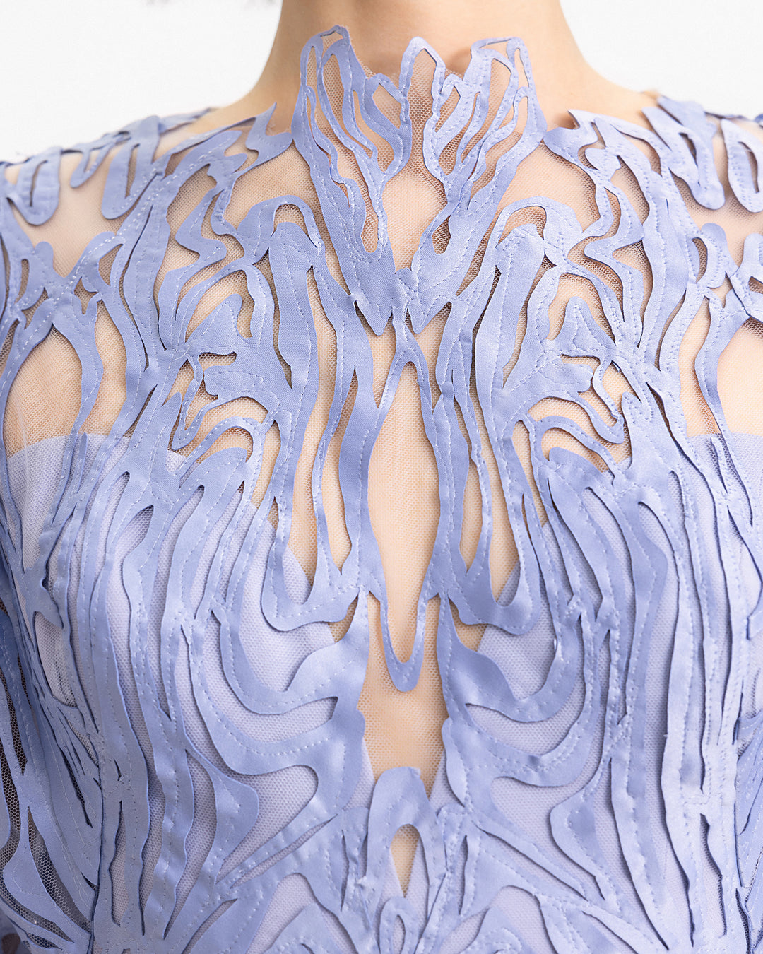 a close-up of a laser-cut embroidered evening dress in dusty blue.