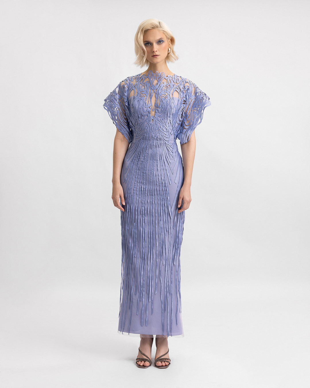 A laser-cut embroidered evening dress in dusty blue with structured half-sleeves.