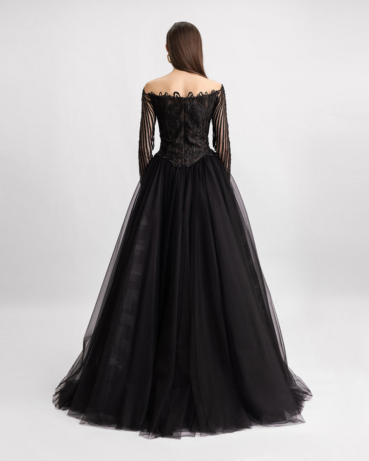 The back of an off-the-shoulders long sleeves evening dress in a laser cut embroidery fabric with a full tulle tail.