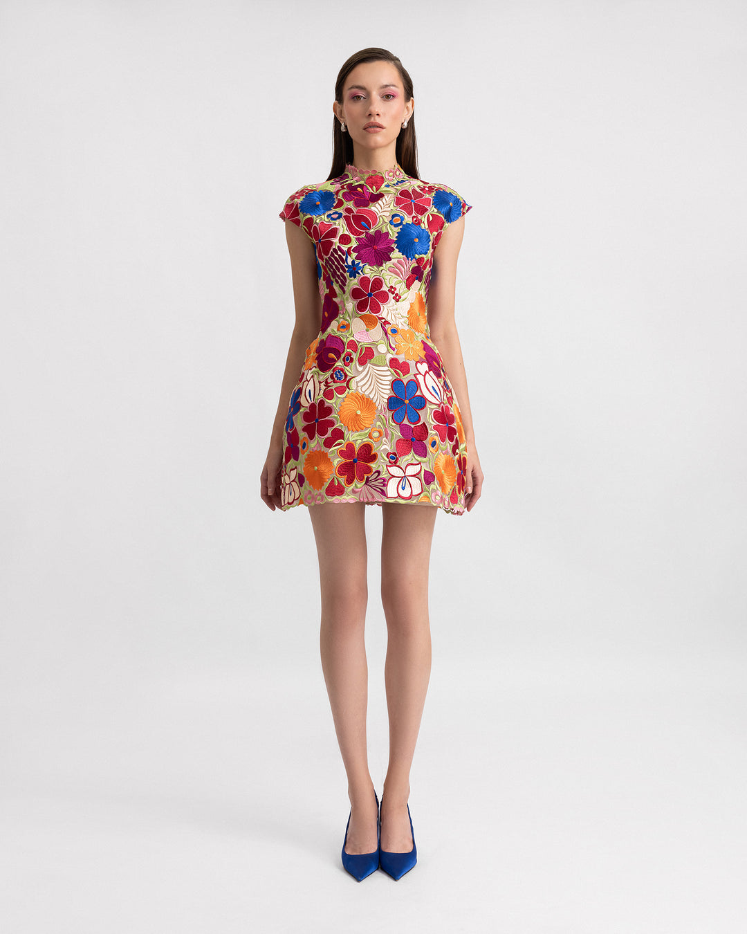 A short structured evening dress in multicolor floral guipure fabric with cap sleeves.