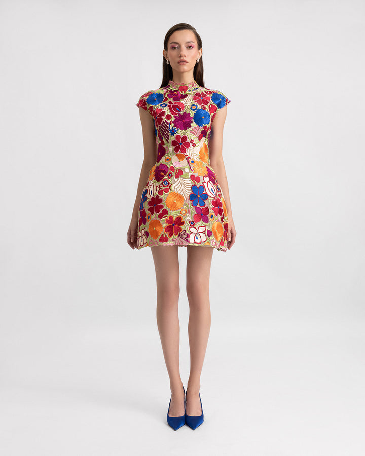 A short structured evening dress in multicolor floral guipure fabric with cap sleeves.