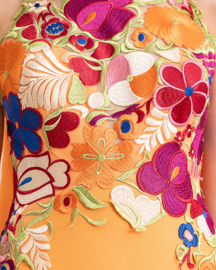 A close-up of an evening dress with a multicolor floral guipure corset.