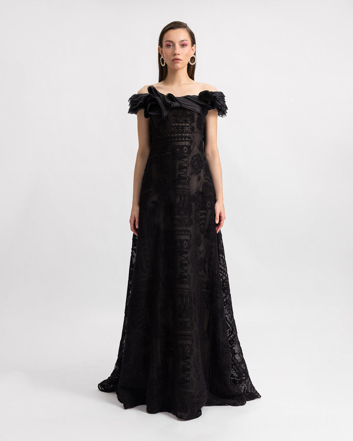 An off-the-shoulders loose-cut black lace evening dress with organza details on the neckline.