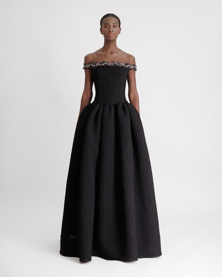 A beaded off-the-shoulders dress with a dropped-down waistline and a draped skirt.