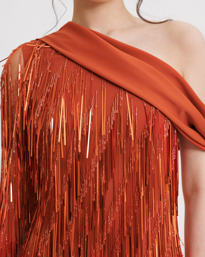 A close-up of a fully beaded fringes evening dress featuring a one-shoulder crepe fold-over.