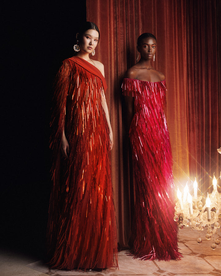 A fully beaded fringes orange dress featuring a one-shoulder crepe fold-over, and a single floor-length sleeve.