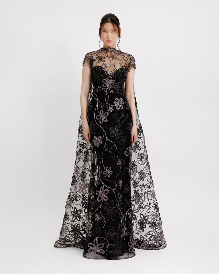 A long floral embroidered tulle black evening dress with a cape-like back.