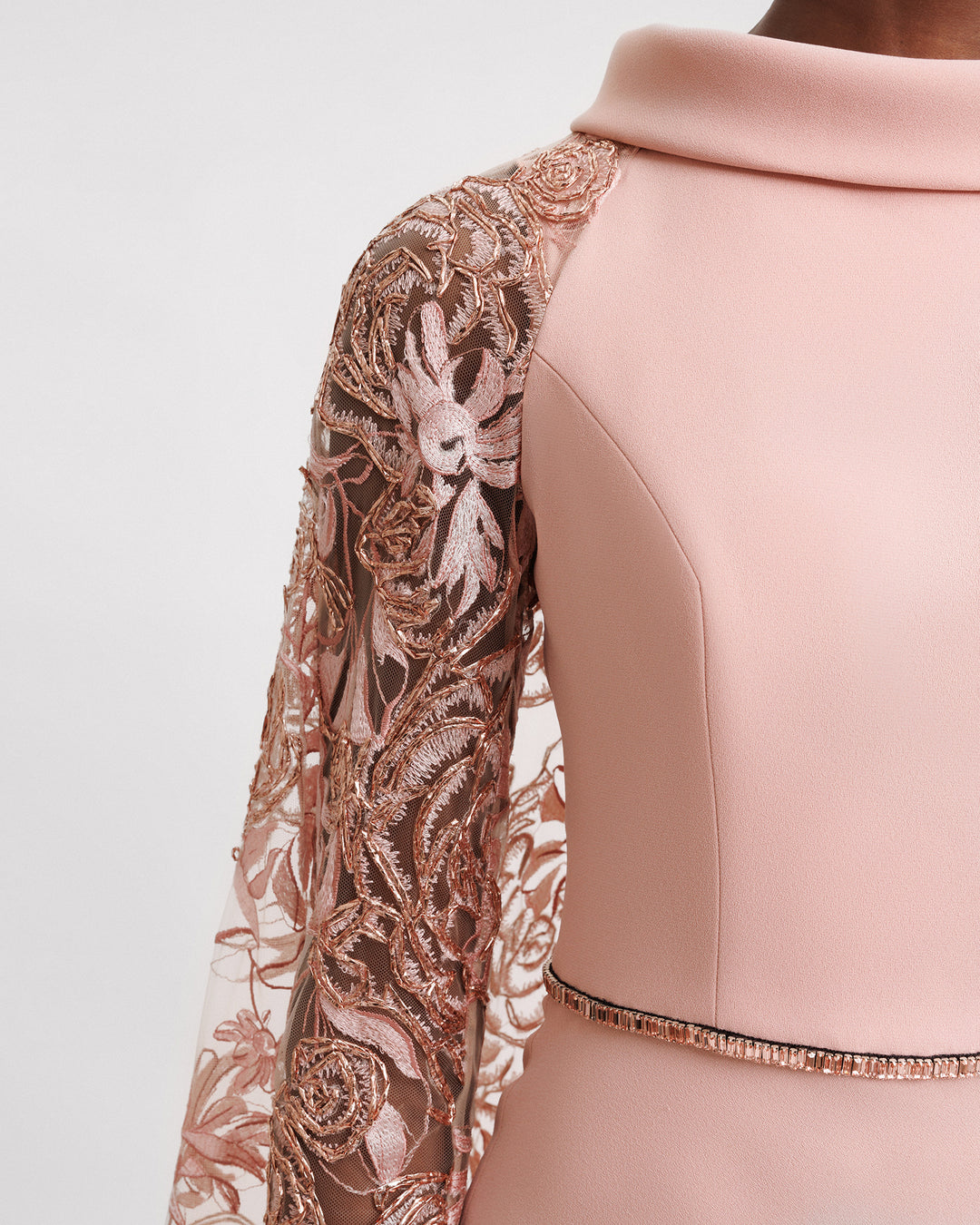 A close-up of a Slim-cut plain evening dress with a fold-over collar, beaded waistline, and cape-like sleeves in floral embroidered tulle.