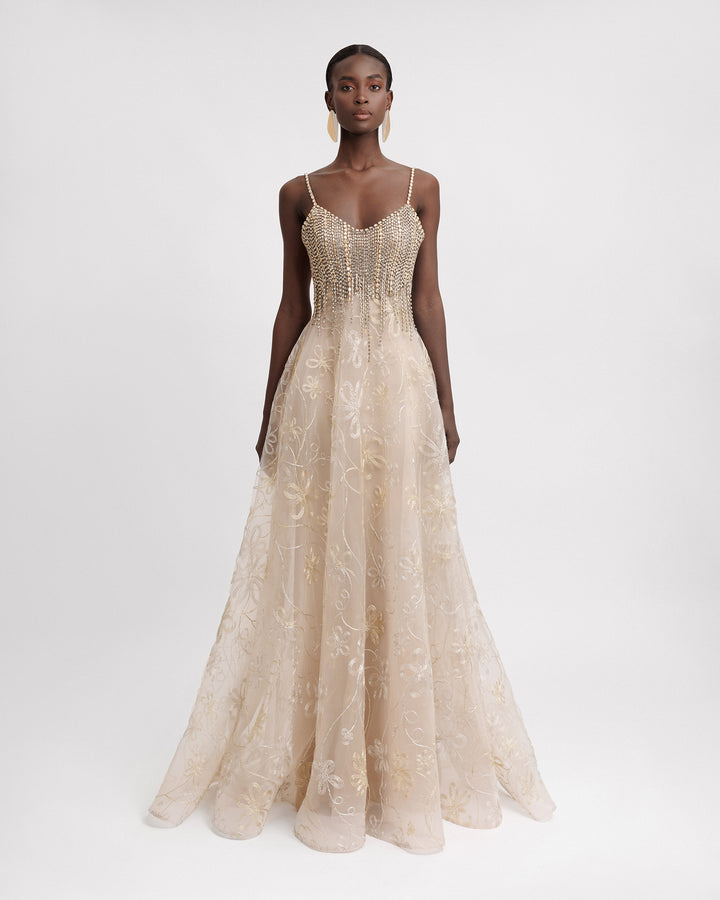 A long evening dress with beaded tassels and a flared embroidered champagne skirt.