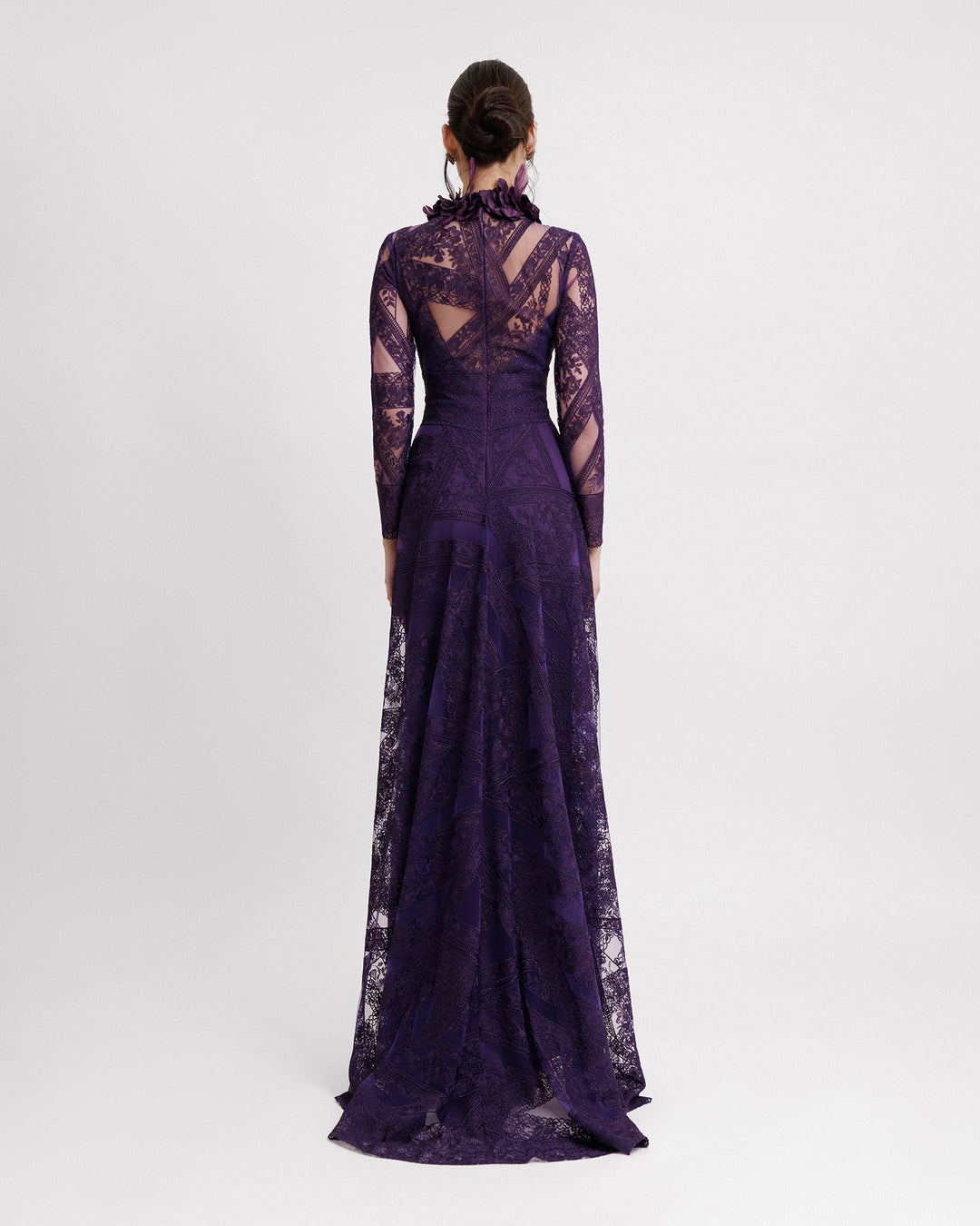 The back of a long sleeved evening dress in purple patterned lace fabric, featuring a see-through open back and embroidered floral feathers on the collar.