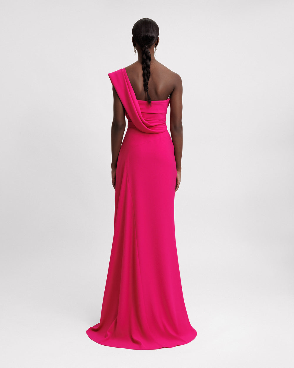 The back of a one-shoulder fuchsia evening dress featuring a draped bodice.