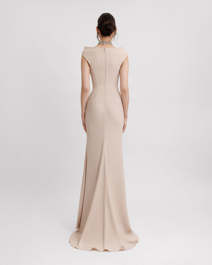 The back of a slim-cut champagne evening dress featuring a strapless boat neckline with a detachable beaded collar.