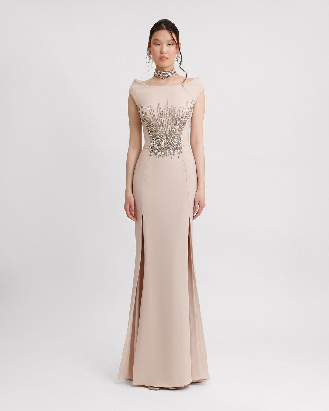 A slim-cut champagne evening dress featuring a strapless boat neckline with a detachable collar, beadings on the corset, and slits on the side.