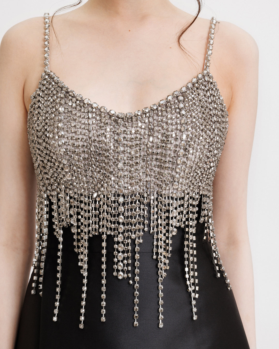 A close-up of an evening dress featuring a beaded tassels bodice on a mikado skirt.