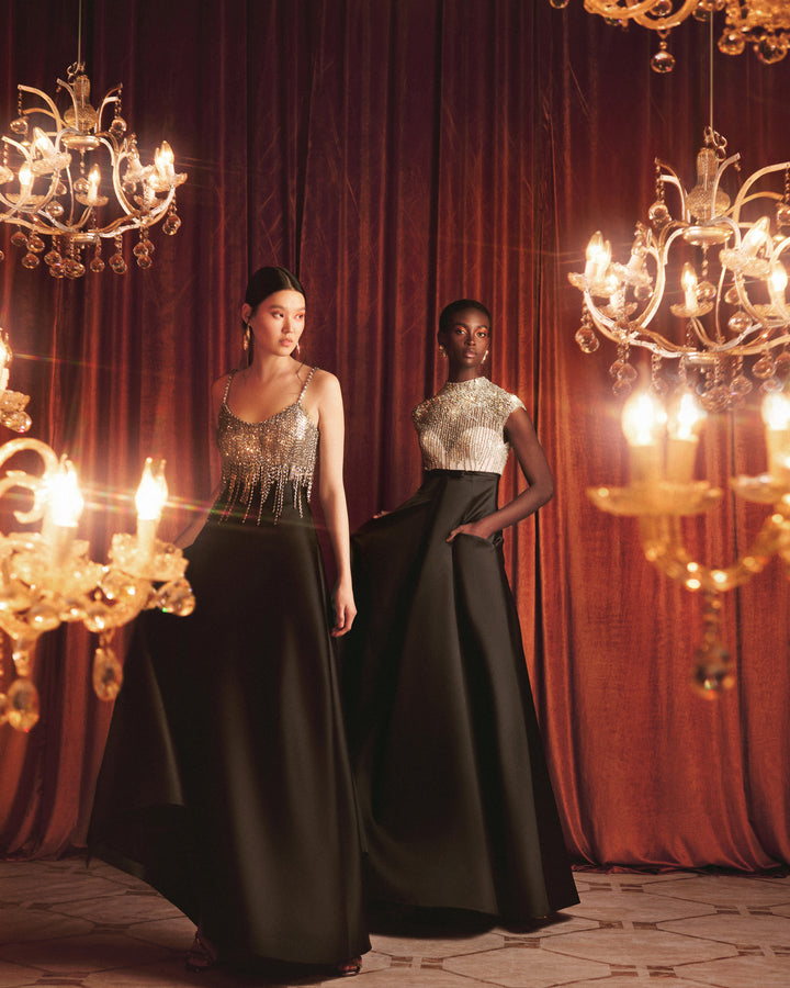 A long black evening dress featuring a beaded silver corset and a wide mikado skirt with pockets.