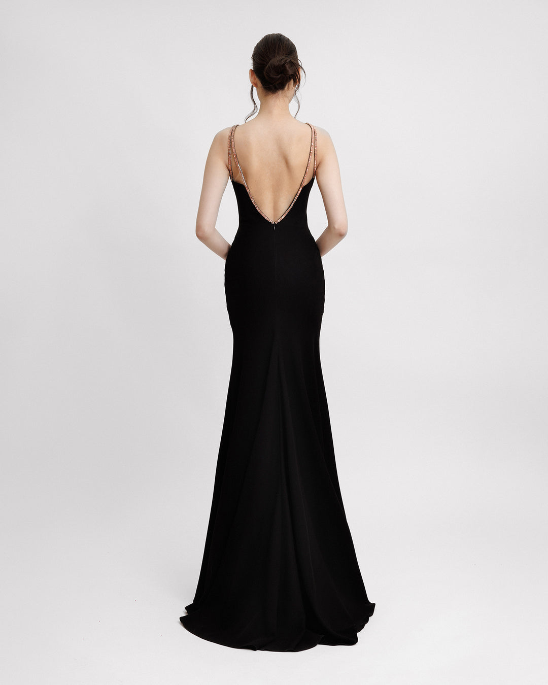 The back of a slim-cut black evening dress featuring a beaded dual straps and an open back.