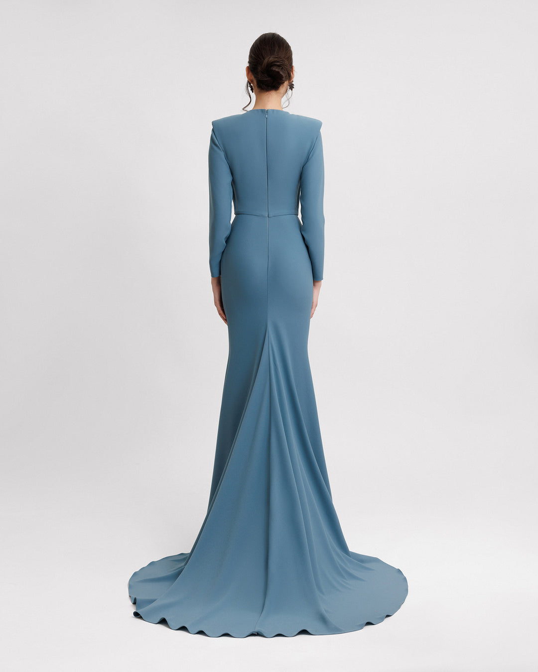 The back of a long sleeves slim-cut evening dress featuring structured shoulders in blue crepe fabric.