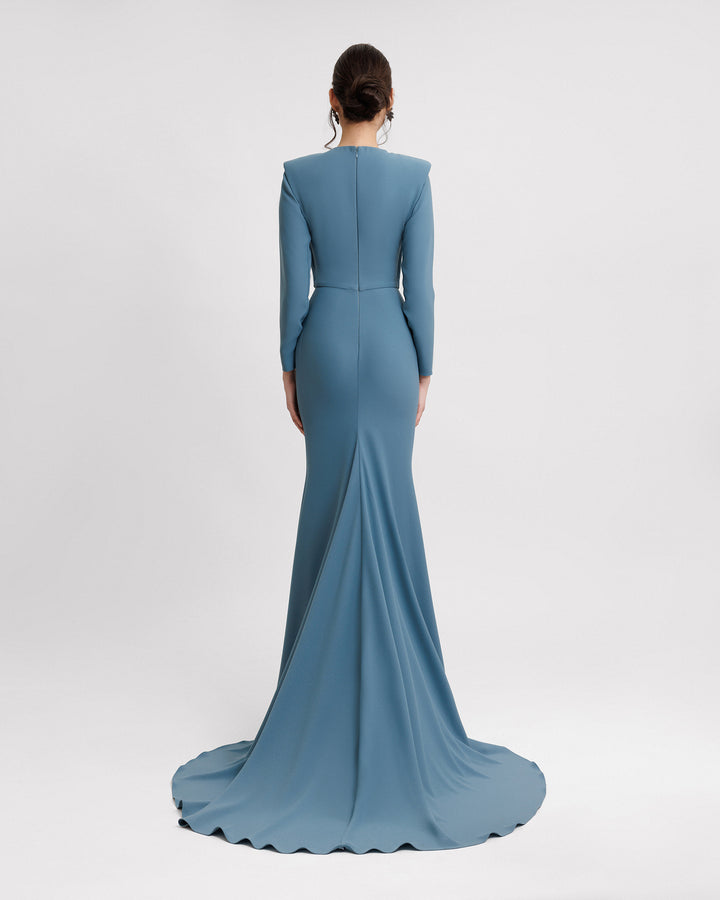 The back of a long sleeves slim-cut evening dress featuring structured shoulders in blue crepe fabric.