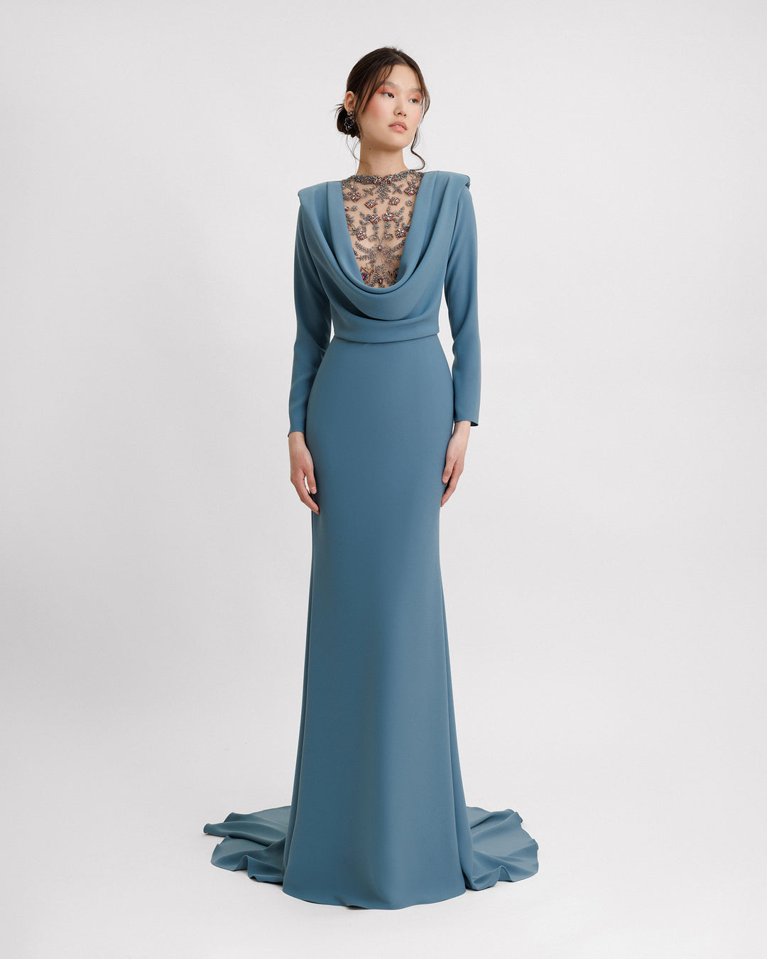 A long sleeves slim-cut evening dress featuring a beaded cowl-neckline with draping and structured shoulders.