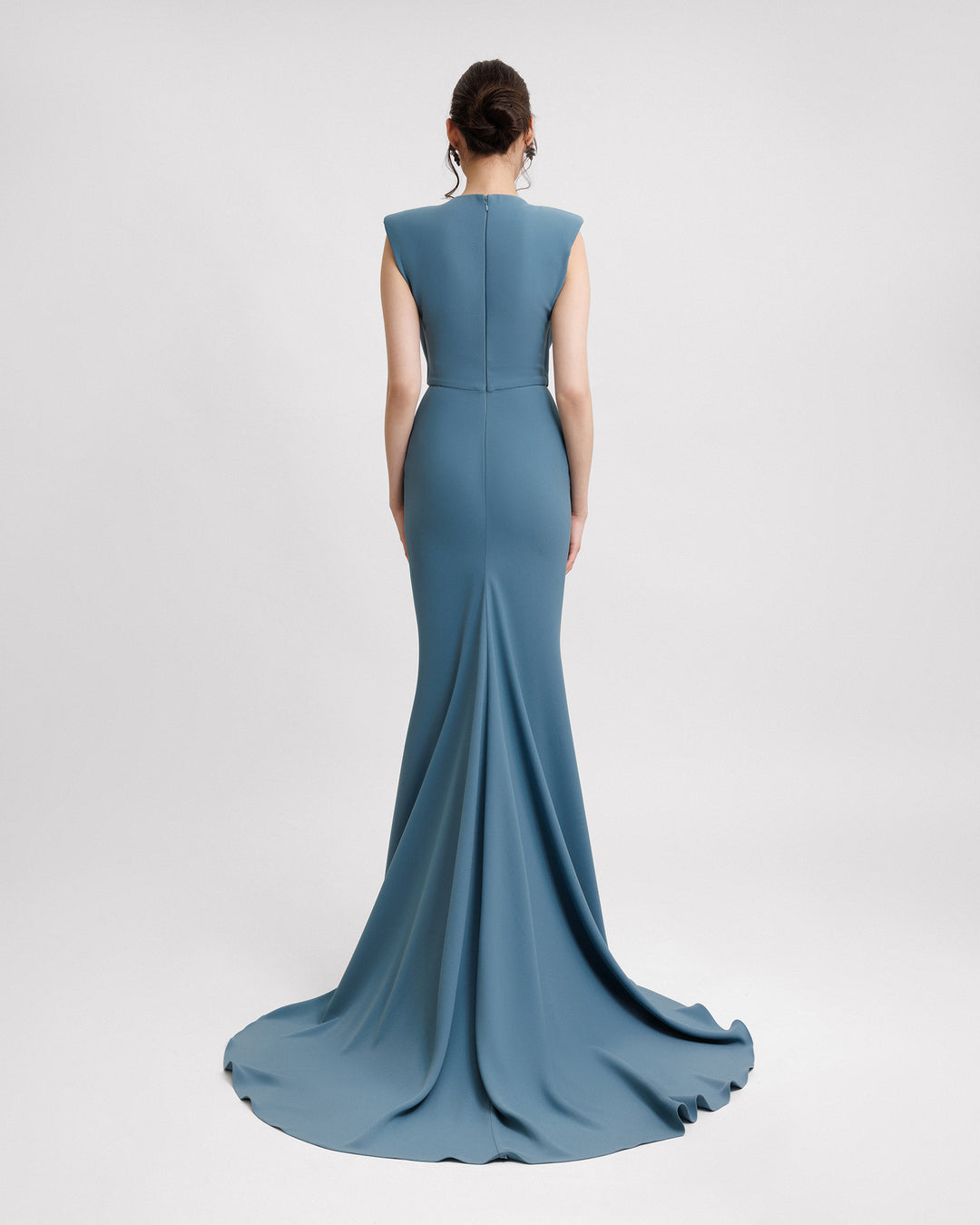 The back of a slim-cut blue evening dress featuring structured shoulders.