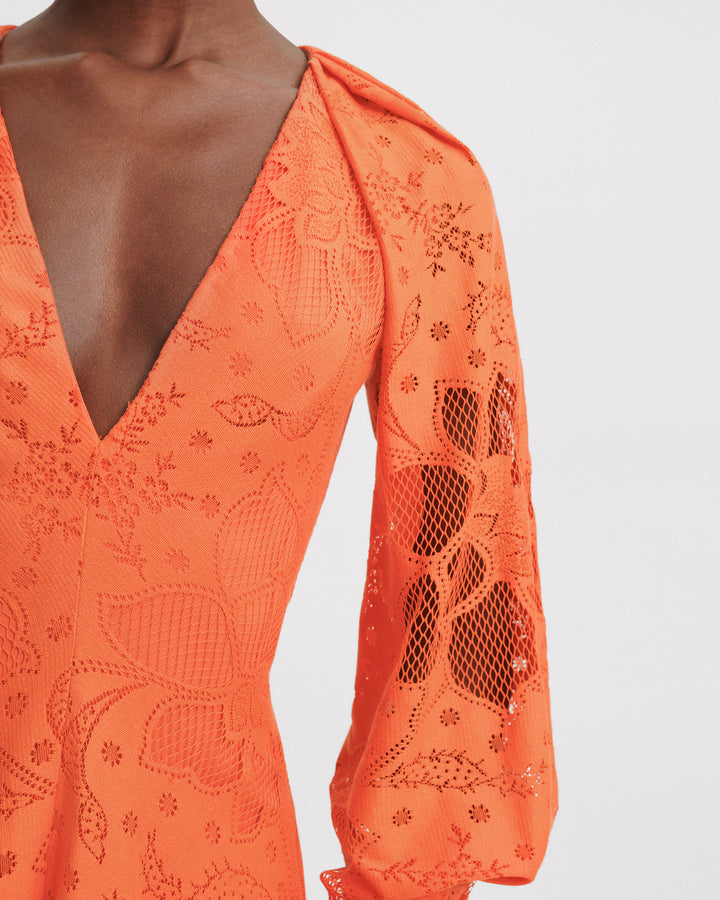 A close-up of a v-neckline orange lace midi dress with draped bishop sleeves.