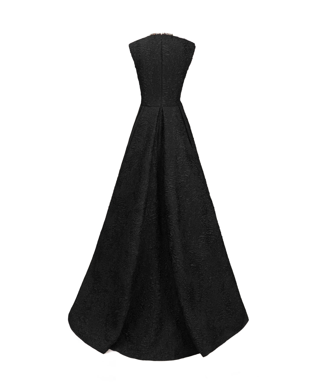 The back of a black evening dress in crinkled jacquard with structured shoulders and a draped flared skirt.