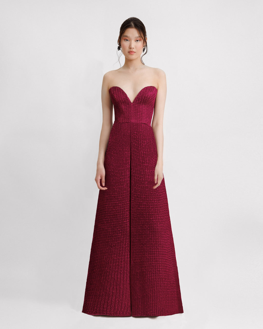 A dark fuchsia strapless evening dress with a plunging neckline and draping on the waistline.