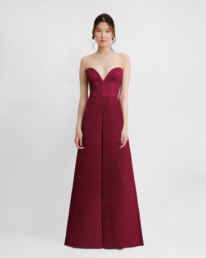 A dark fuchsia strapless evening dress with a plunging neckline and draping on the waistline.