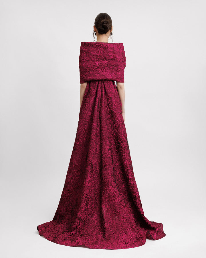 The back of a dark fuchsia evening dress paired with a detachable cape.