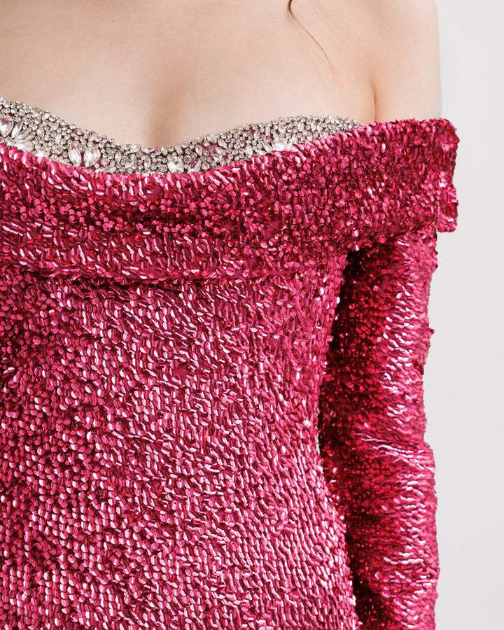 A close-up of a fully sequined off-the-shoulders evening dressing fuchsia with a beaded heart shaped neckline and long sleeves.