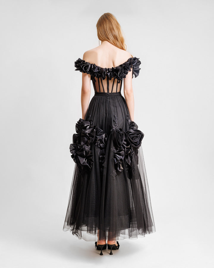 The back of a black midi dress with off-the-shoulders draped florals featuring a see-through corset and a flared tulle skirt with floral draping.