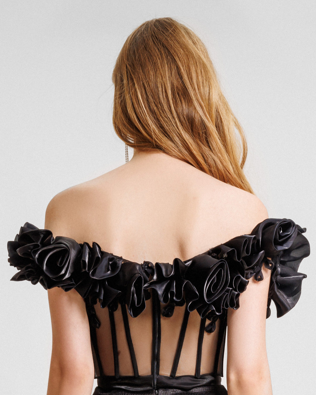 The back of an off-the-shoulders draped floral corset with a see-though bodice.