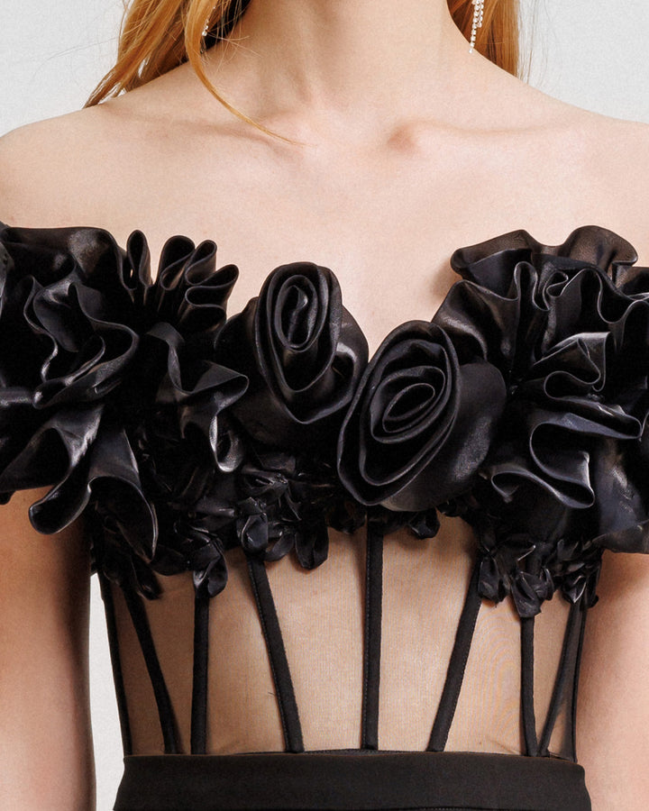 A close-up of an off-the-shoulders draped floral corset with a see-though bodice.