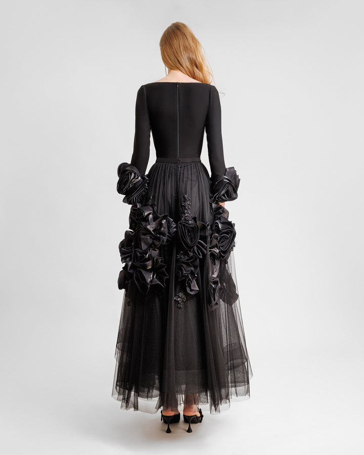 The back of a midi evening dress featuring a squared-neckline crepe top gathered with a midi tulle skirt adorned with floral cuffs and and embellishments on the skirt.